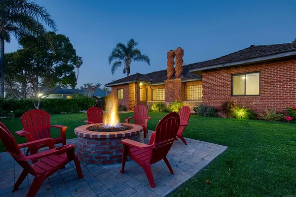 a view of a backyard with furniture and a fire pit