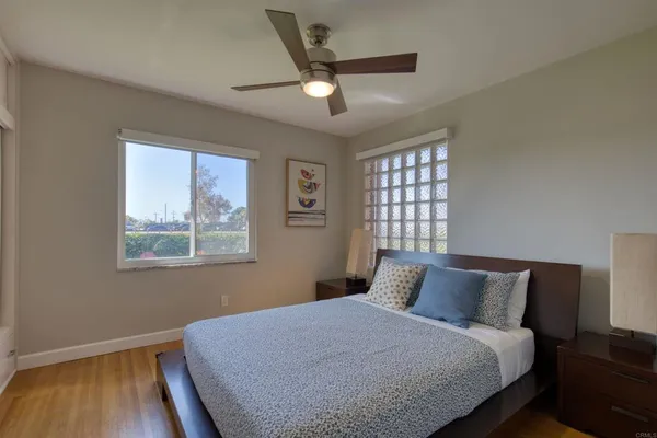 a bedroom with a bed and a painting on the wall