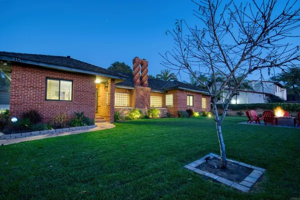 a backyard of a house with plants and large trees