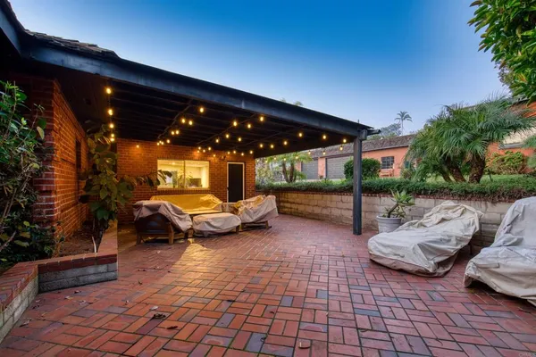 a view of a patio with table and chairs with plants and wooden fence