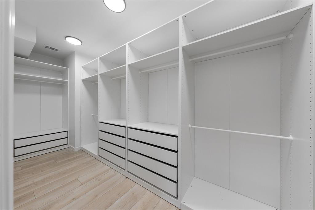 14140 Regency Place Dallas, TX 75254 - Photo 26 of 38 Custom white built-in closet system featuring multiple shelving units, hanging rods, and integrated drawers with black hardware