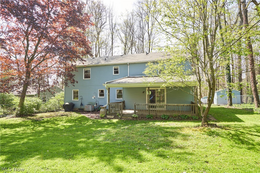 3097 Baughman Road Clinton, OH 44216 - Photo 24 of 27 Expansive green lawn with mature trees and a rear deck