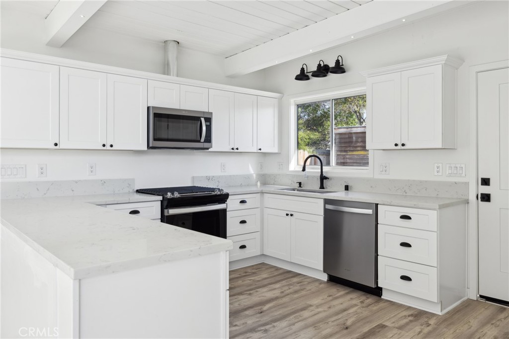 528 Creston Road Paso Robles, CA 93446 - Photo 24 of 46 a kitchen with granite countertop white cabinets a sink a window and stainless steel appliances