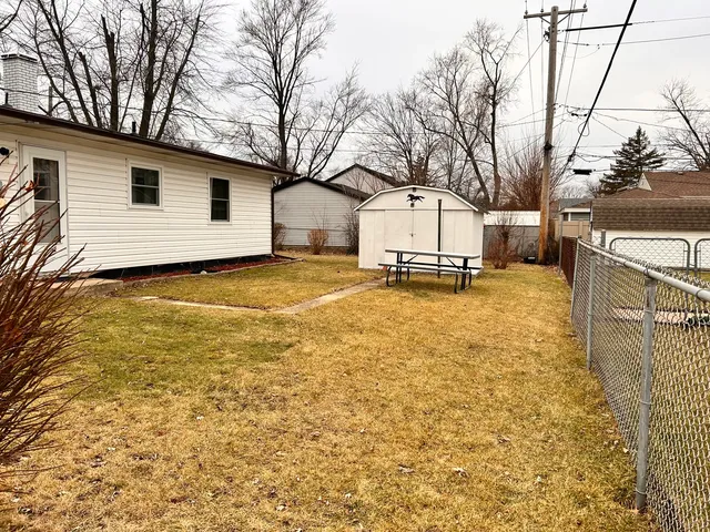 a backyard of a house with table and chairs