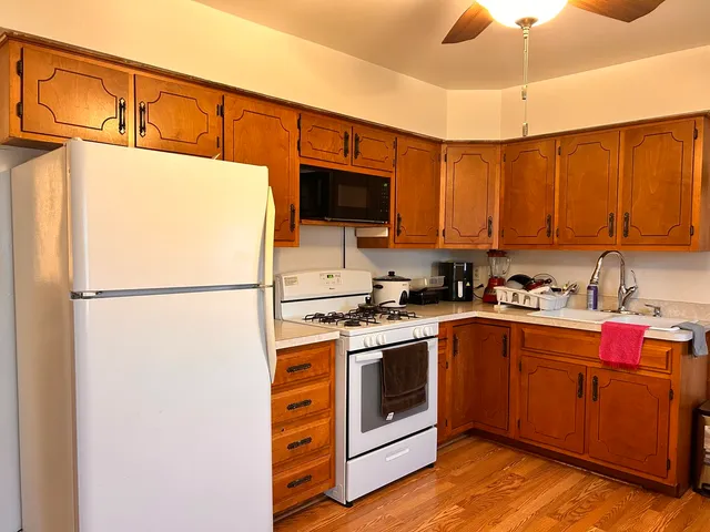 a kitchen with stainless steel appliances granite countertop a refrigerator a stove a sink and a microwave