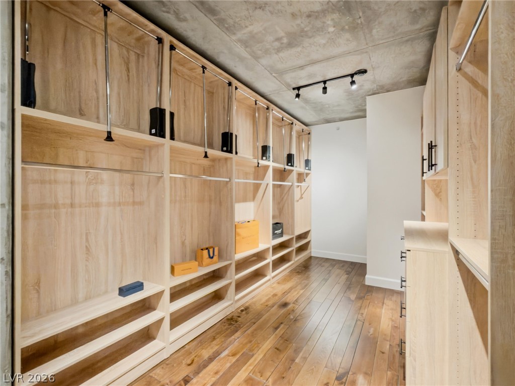 360 East Desert Inn Road, Unit 607 Las Vegas, NV 89109 - Photo 29 of 55 Ample storage solutions and rich wood flooring create an inviting and functional walk-in closet.