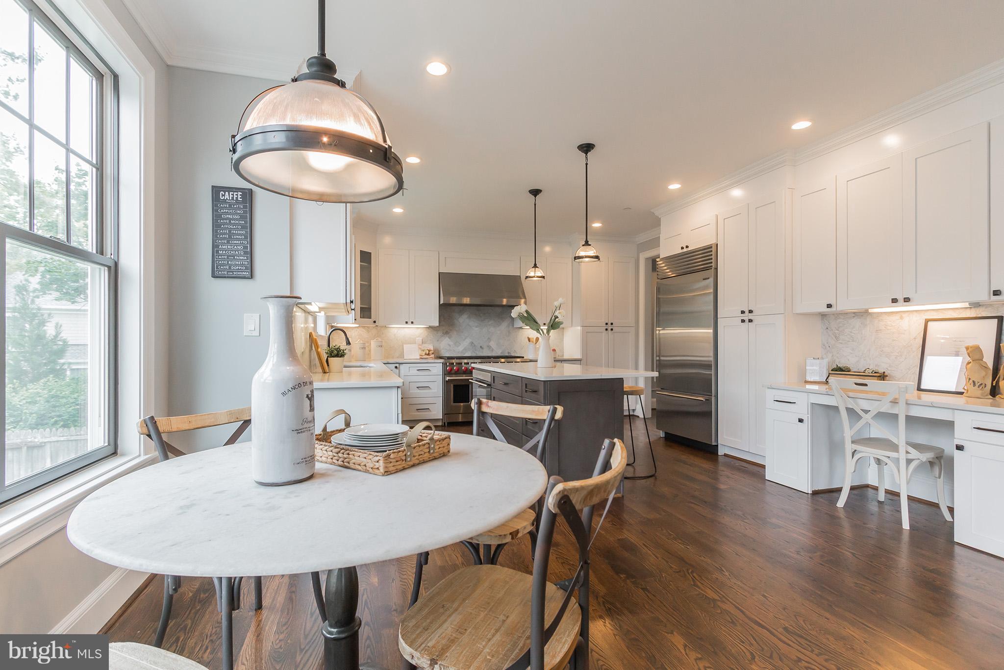 736 Thayer Avenue Silver Spring, MD 20910 - Photo 10 of 30 a kitchen with stainless steel appliances kitchen island granite countertop a kitchen island a stove a table and chairs in it