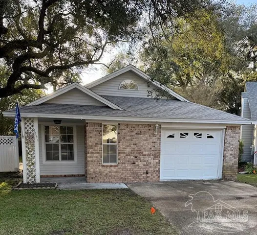 a brick house with a large tree in front of it