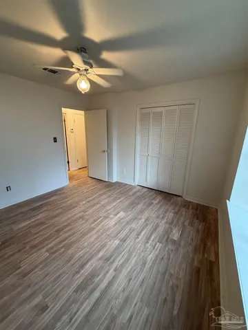 a view of empty room with wooden floor