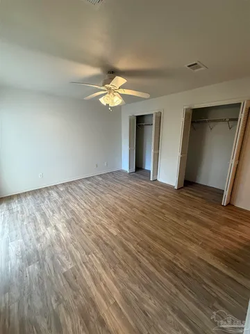 a view of empty room with window and ceiling fan