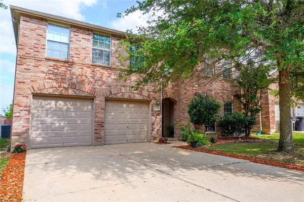 front view of a brick house with a yard
