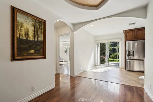 a view of a hallway with wooden floor and a living room