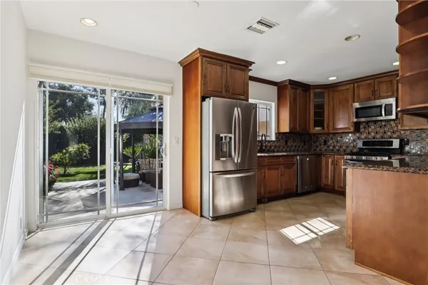 a kitchen with stainless steel appliances granite countertop a refrigerator and a stove top oven