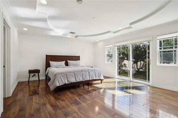 a bedroom with a large bed and painting on the wall