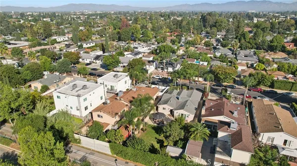 an aerial view of residential houses with outdoor space and trees