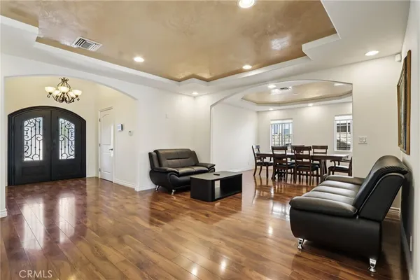 a living room with furniture a dining table and wooden floor