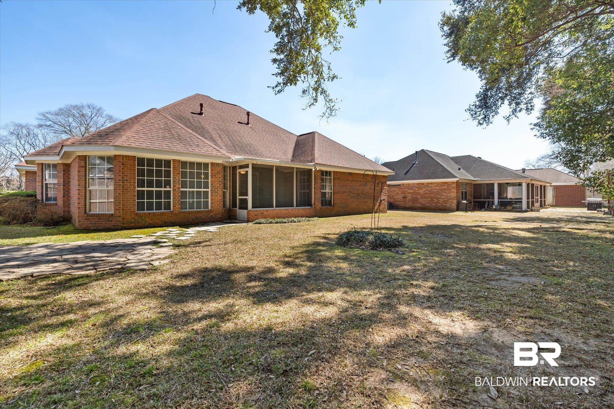 2220 Irongate Court Mobile, AL 36695 - Photo 20 of 20 Rear view of house featuring a sunroom, brick siding, and a lawn