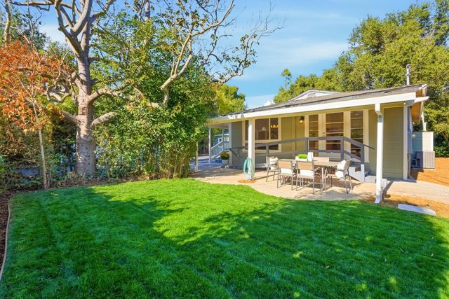 a view of a porch with chairs and potted plants
