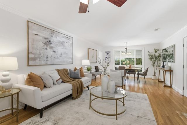 a large kitchen with kitchen island a large window a sink and stainless steel appliances