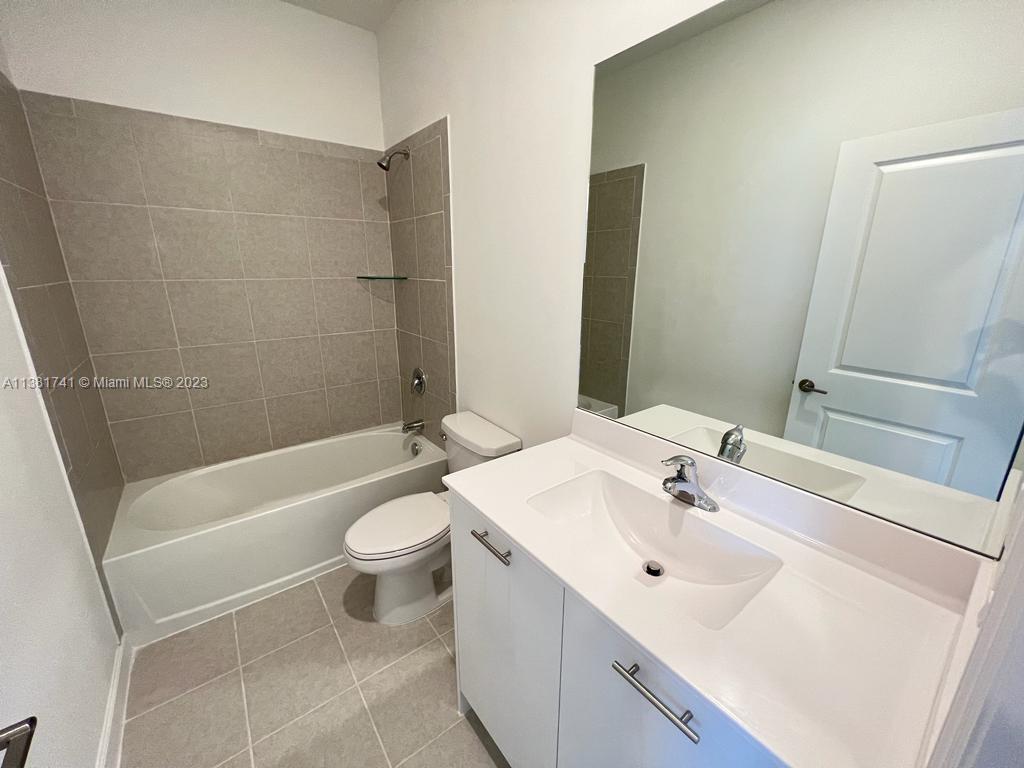 12958 Northwest 23rd Place, Unit 12958 Miami, FL 33167 - Photo 15 of 23 a bathroom with a sink a toilet and shower