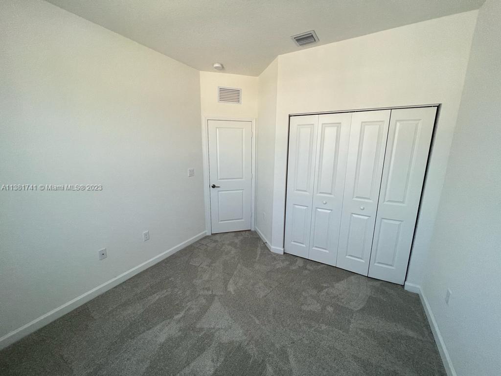 12958 Northwest 23rd Place, Unit 12958 Miami, FL 33167 - Photo 19 of 23 an empty room with a wooden door