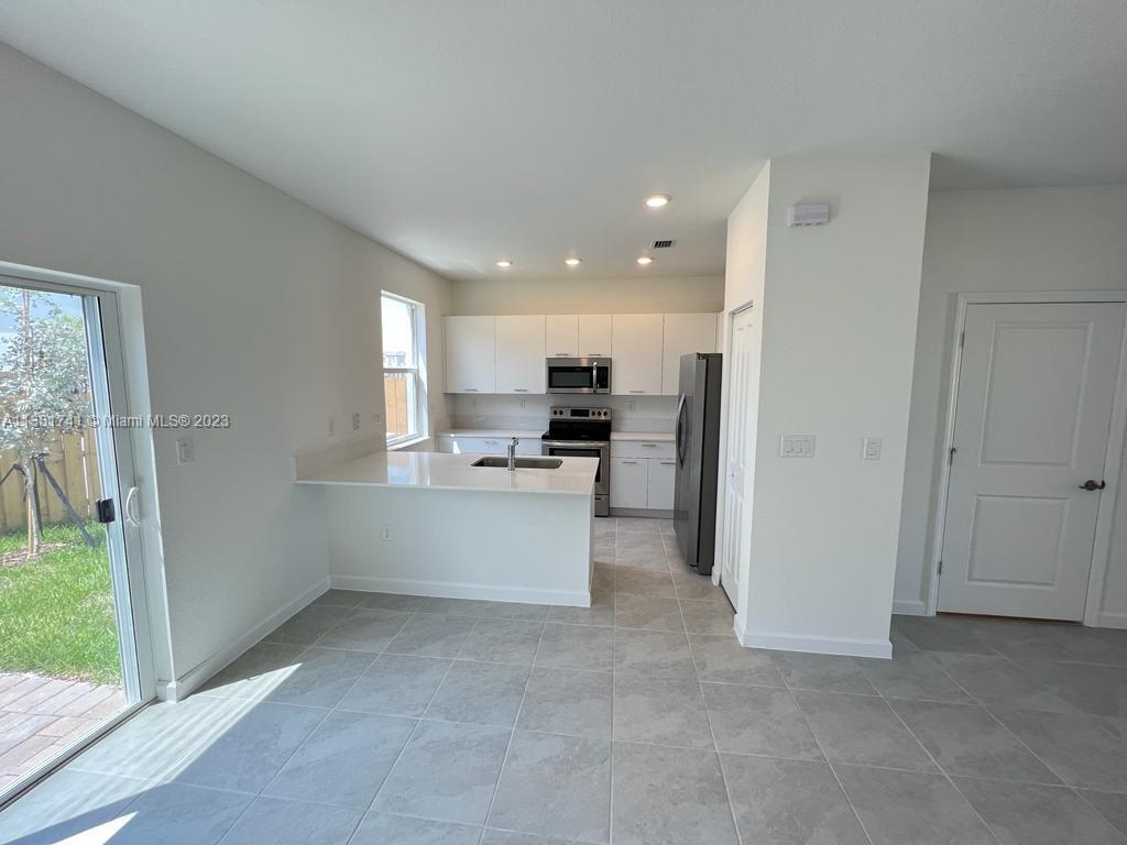 12958 Northwest 23rd Place, Unit 12958 Miami, FL 33167 - Photo 3 of 23 a view of kitchen with refrigerator sink and microwave
