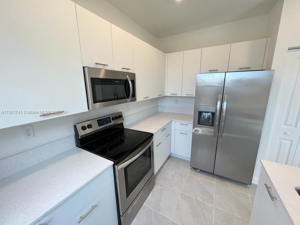 12958 Northwest 23rd Place, Unit 12958 Miami, FL 33167 - Photo 6 of 23 a kitchen with a refrigerator stove and microwave