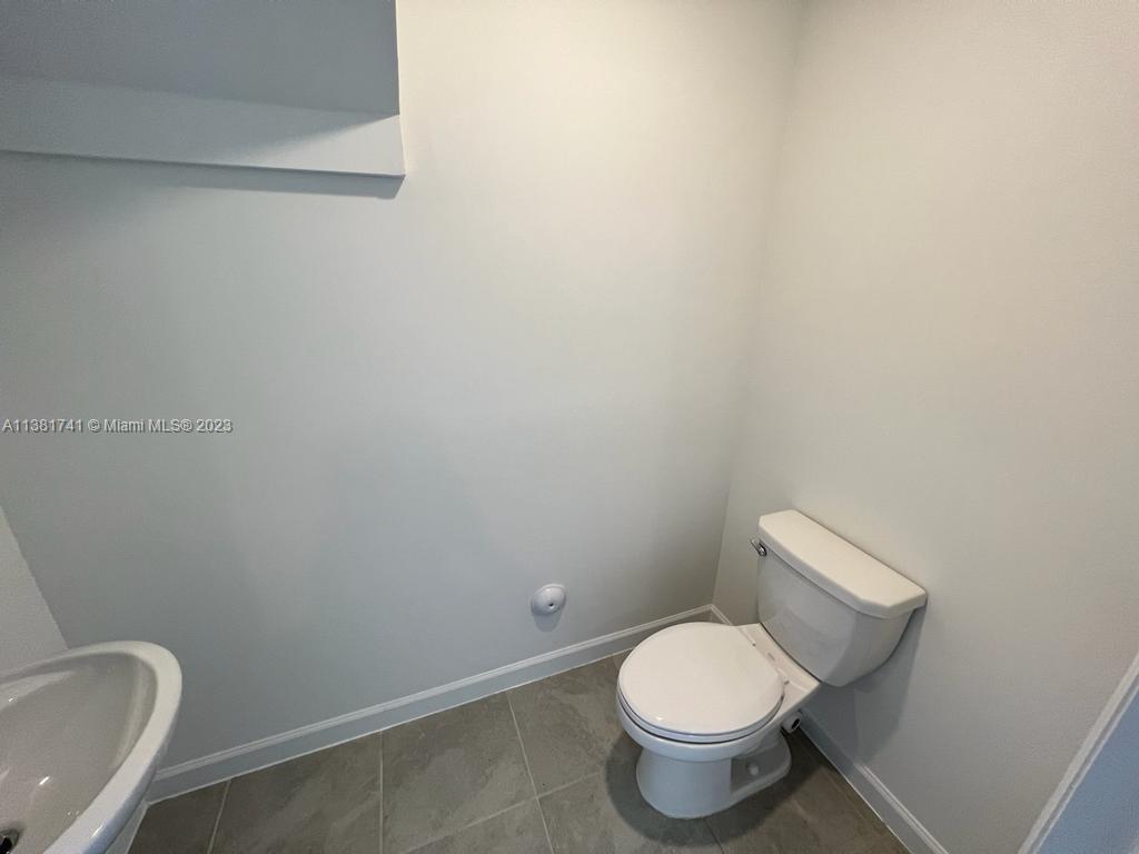 12958 Northwest 23rd Place, Unit 12958 Miami, FL 33167 - Photo 10 of 23 a white toilet sitting next to a white wall