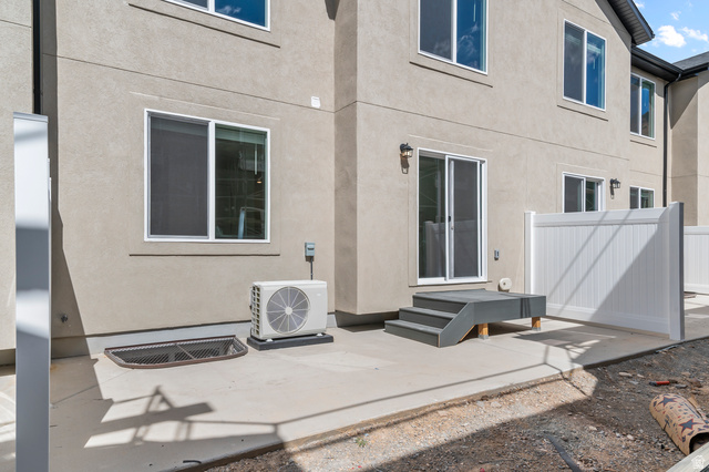 1907 East 640th North, Unit 1225 Salem, UT 84653 - Photo 13 of 20 Concrete patio with a gray two-step deck, providing access to a sliding glass door