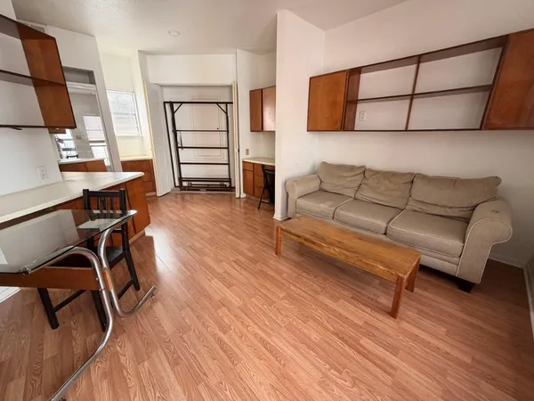 a living room with furniture a flat screen tv and wooden floor