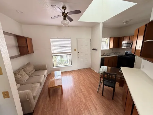 a living room with furniture and a wooden floor