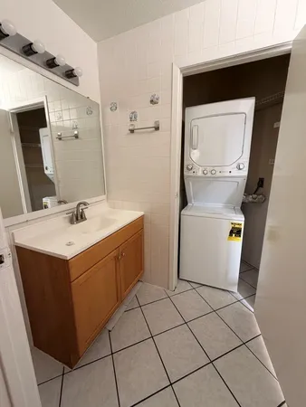 a utility room with a sink a toilet and a mirror