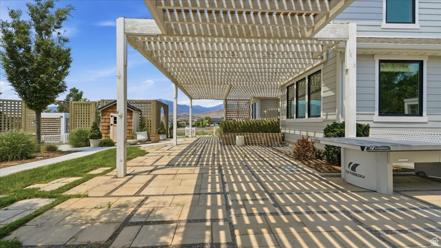 2038 East Ranch Road Eagle Mountain, UT 84005 - Photo 46 of 66 Expansive outdoor patio featuring a slatted pergola, stone paver flooring, manicured lawn, and a wooden storage shed