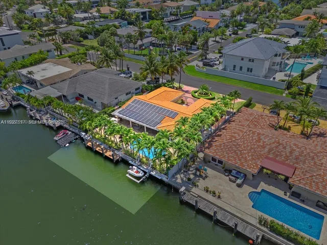 an aerial view of a house with a garden and lake view