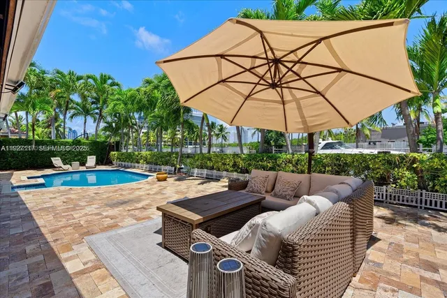 a view of a patio with couches and table under an umbrella
