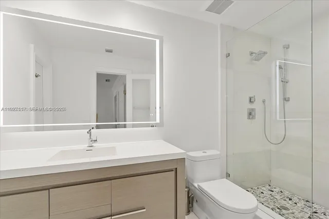 a bathroom with a sink a toilet and shower