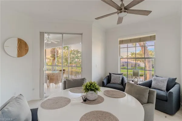 a dining room with furniture a large window and a chandelier