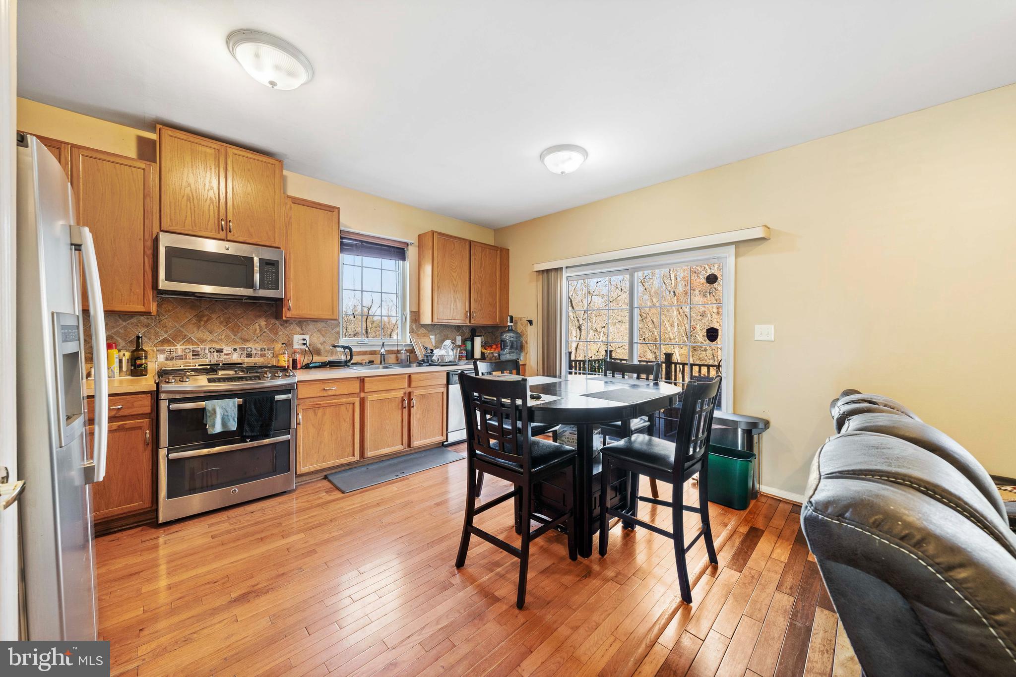 33 Cayuga Road Bordentown, NJ 08505 - Photo 6 of 30 a kitchen with stainless steel appliances granite countertop a stove top oven a sink dishwasher a dining table and chairs with wooden floor