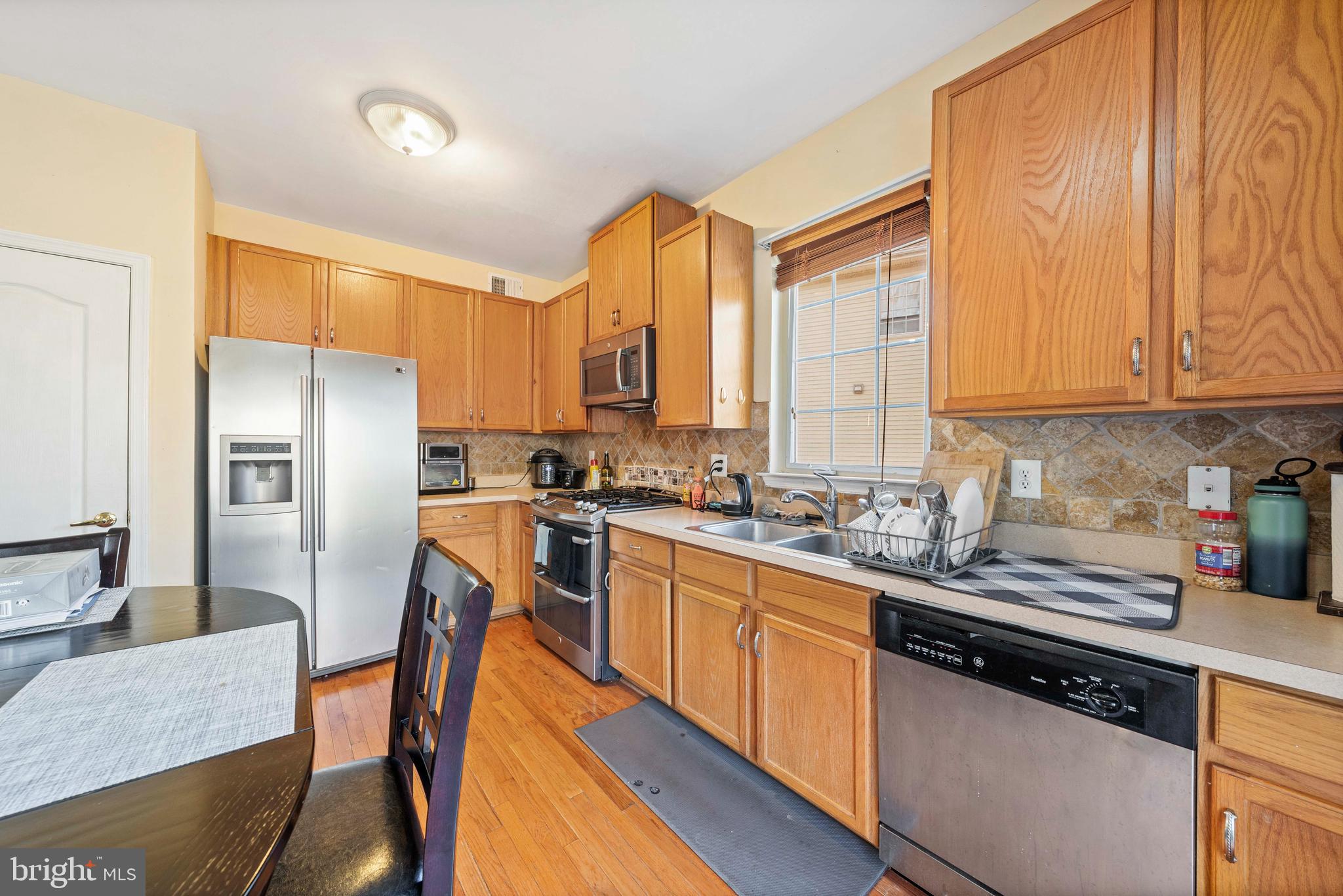 33 Cayuga Road Bordentown, NJ 08505 - Photo 7 of 30 a kitchen with stainless steel appliances granite countertop a stove a sink a refrigerator white cabinets and wooden floor