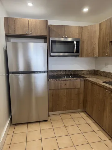 a utility room with cabinets and a refrigerator