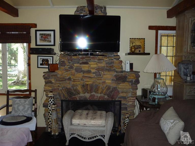 588 Cold Canyon Road Calabasas, CA 91302 - Photo 4 of 7 a living room with furniture a flat screen tv and a fireplace
