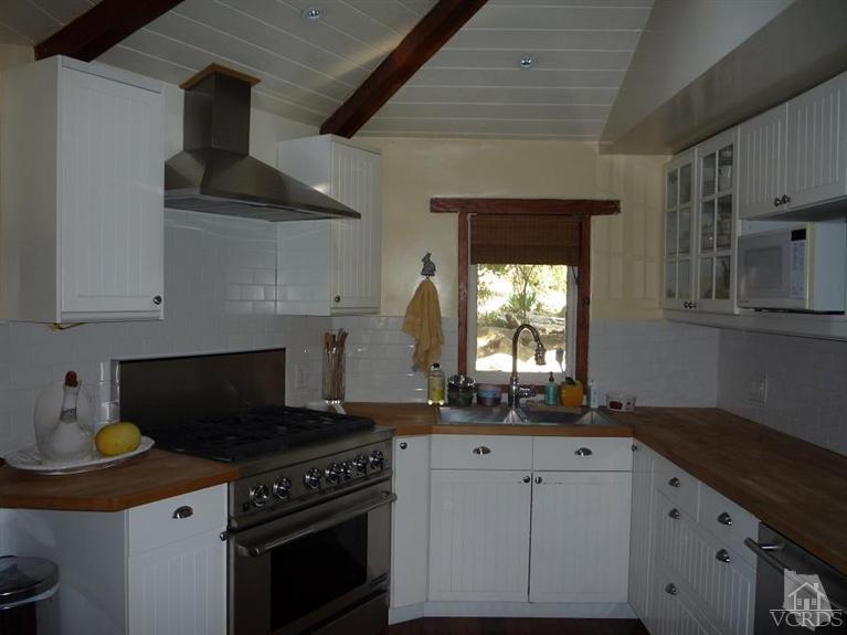 588 Cold Canyon Road Calabasas, CA 91302 - Photo 5 of 7 a kitchen with granite countertop a sink a stove and cabinets