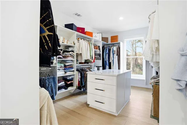 a view of walk in closet with clothes and shoes