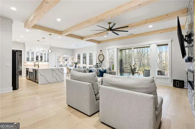 a living room with furniture a large window with kitchen view