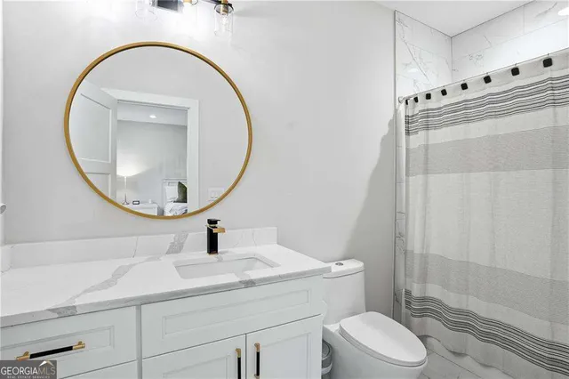 a bathroom with a sink a toilet and a mirror