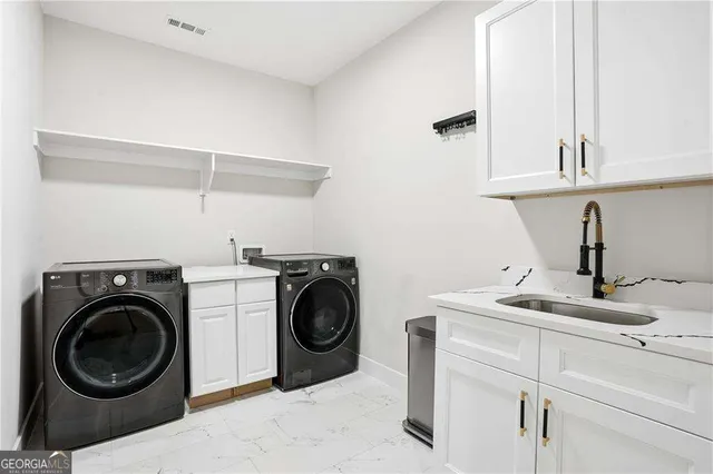 a utility room with sink dryer and washer