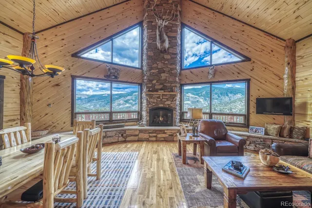 a living room with furniture large window and wooden floor