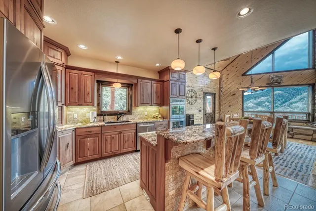a kitchen with stainless steel appliances granite countertop sink stove and refrigerator