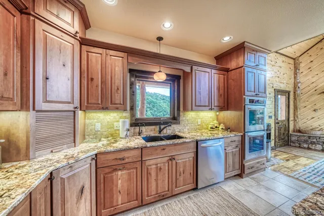 a kitchen with kitchen island granite countertop a sink window and cabinets