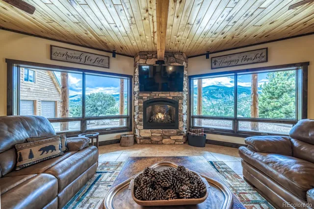 a living room with furniture a fireplace and a floor to ceiling window